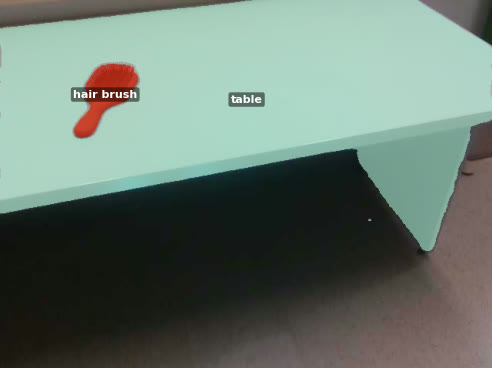 Segmented camera view showing a hair brush on a table.